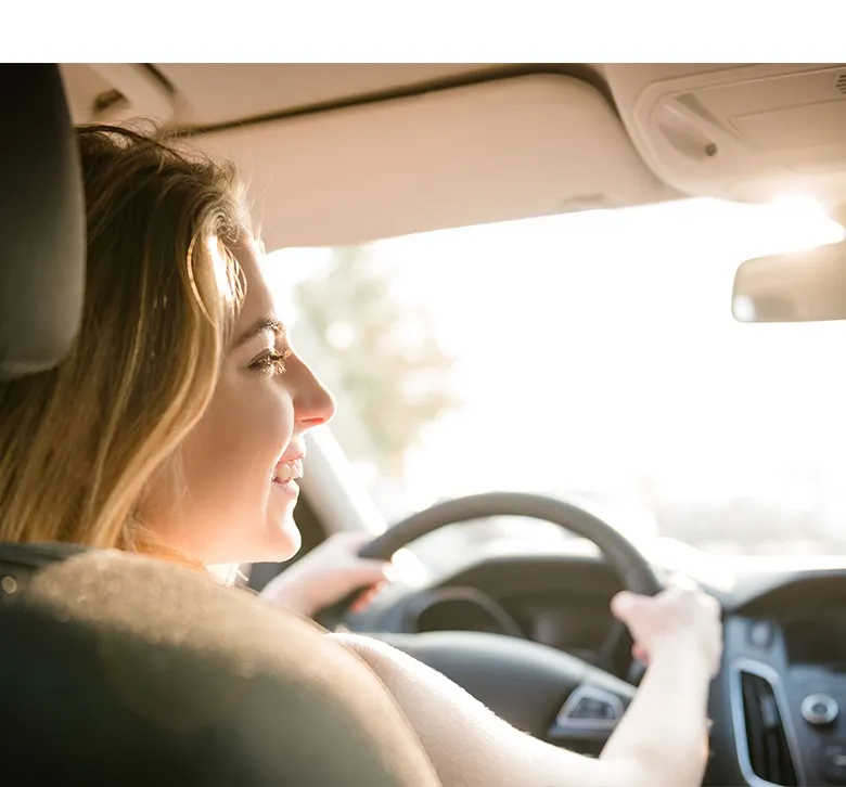 Mujer conduciendo su auto sonriente