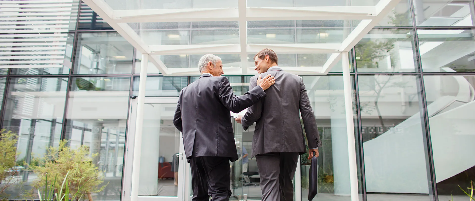 Dos profesionales conversando en la entrada de una oficina